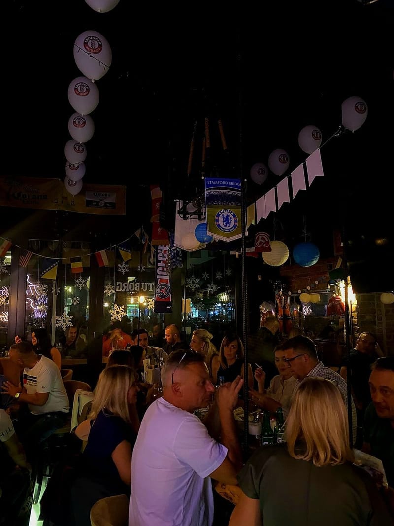Pun pub navečer, s balonima i šalovima iznad gostiju.